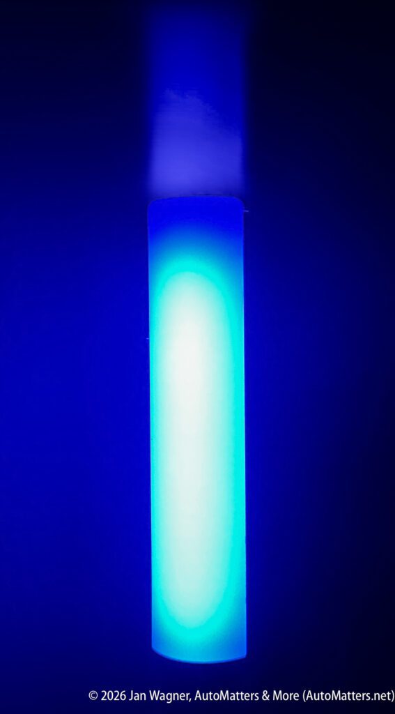 A vertical cylindrical object emits a bright blue light, illuminating the surrounding area with a blue glow.