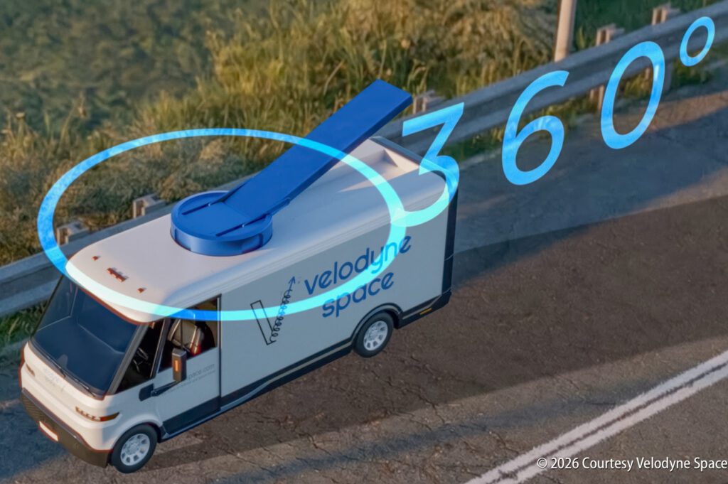 A Velodyne Space van with a rooftop 360-degree sensor is parked near a road and grassy area, demonstrating advanced vehicle sensing technology.
