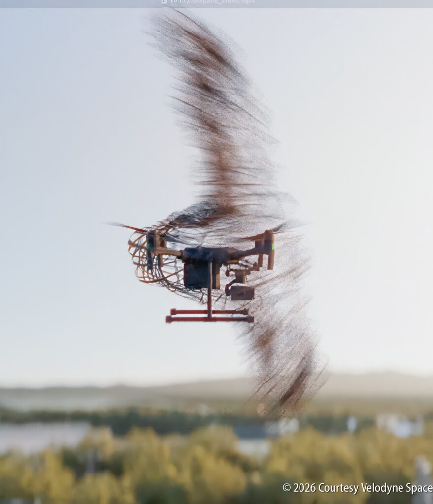 A drone in flight with blurred rotors, capturing motion against a landscape background; © 2026 Courtesy Velodyne Space.