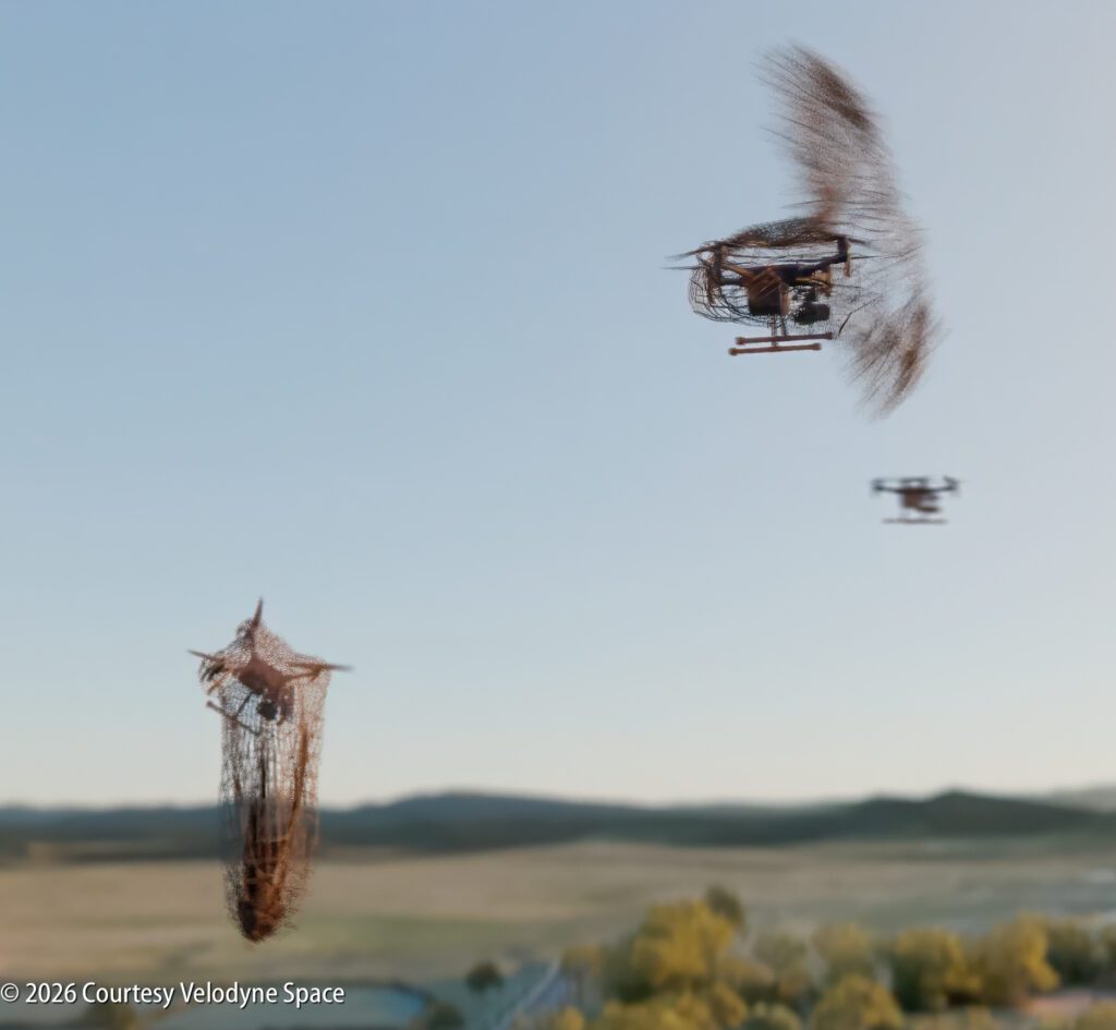 A drone captures another drone in a net mid-air, while a third drone flies in the background over a landscape.