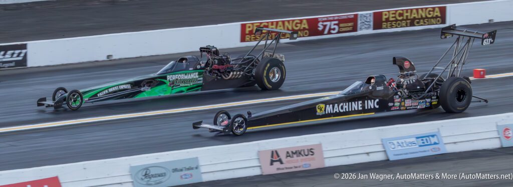 Two drag racing cars accelerate side by side on a drag strip, with "Machine Inc" and "RepairPal" branding visible on the cars.