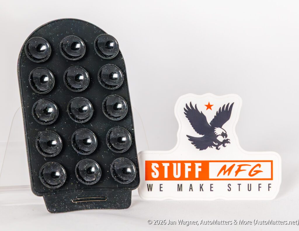 A black suction cup pad is displayed next to a white sticker featuring an eagle, an orange star, and the text "STUFF MFG WE MAKE STUFF.