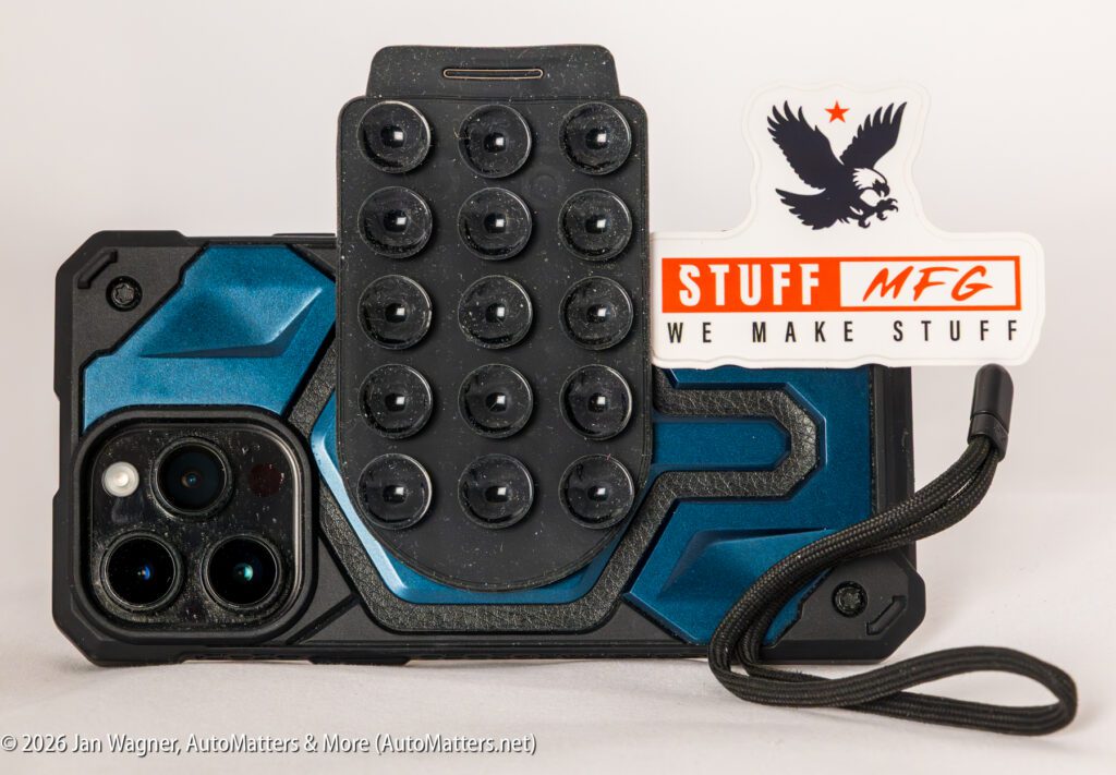 A rugged blue and black smartphone case with a suction cup phone mount and a "STUFF MFG WE MAKE STUFF" sticker attached.