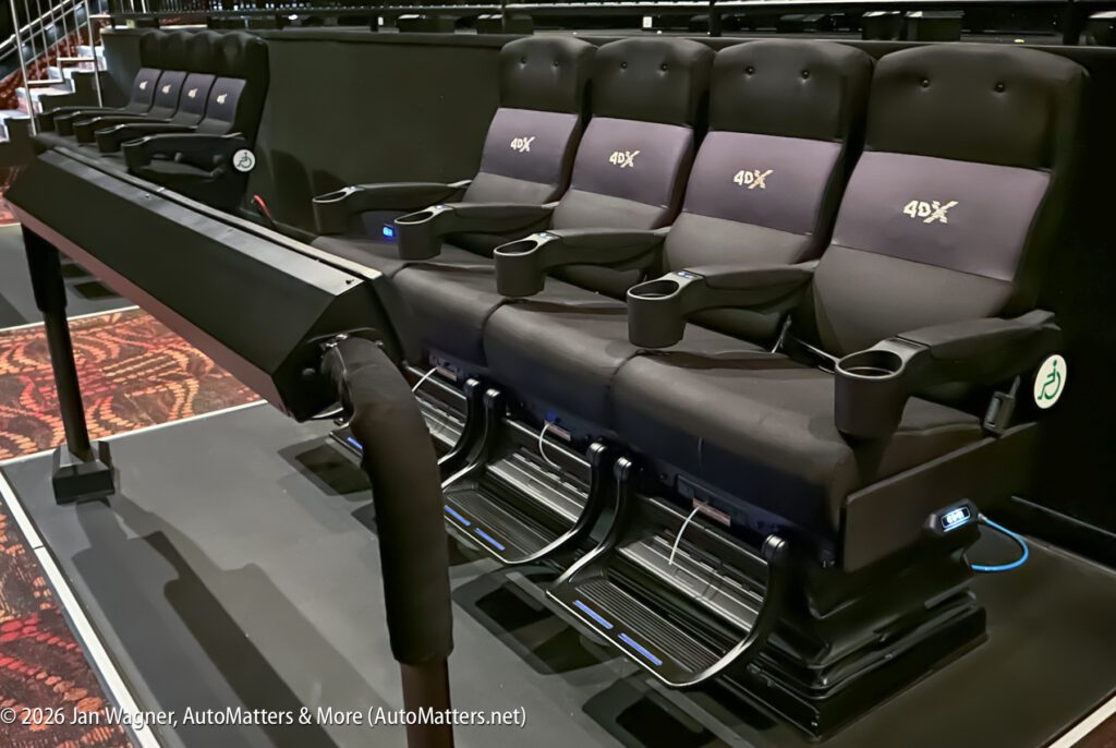 Row of 4DX movie theater seats with footrests, motion platforms, and special effects equipment, designed for an immersive viewing experience.