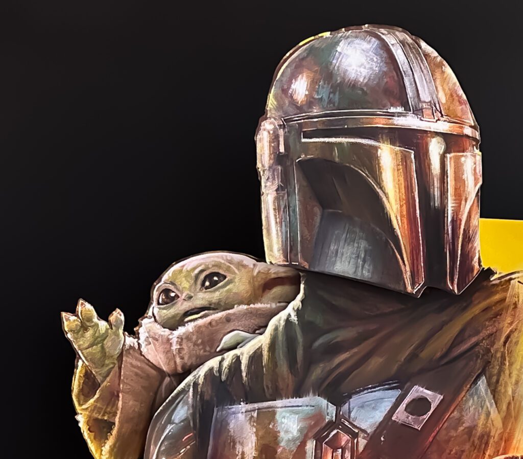 A person in Mandalorian armor stands next to a small green alien character, known as Grogu, against a dark background.