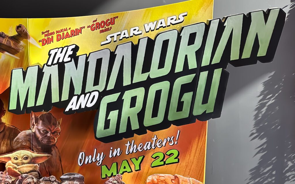 Movie poster for "The Mandalorian and Grogu" features bold text, images of characters, and announces a theater release date of May 22.