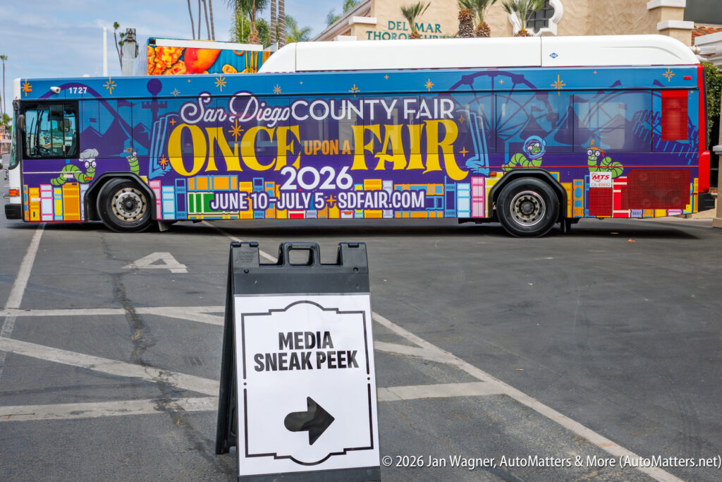 A colorful bus promoting the 2026 San Diego County Fair is parked behind a sign that reads “MEDIA SNEAK PEEK” with an arrow pointing left.