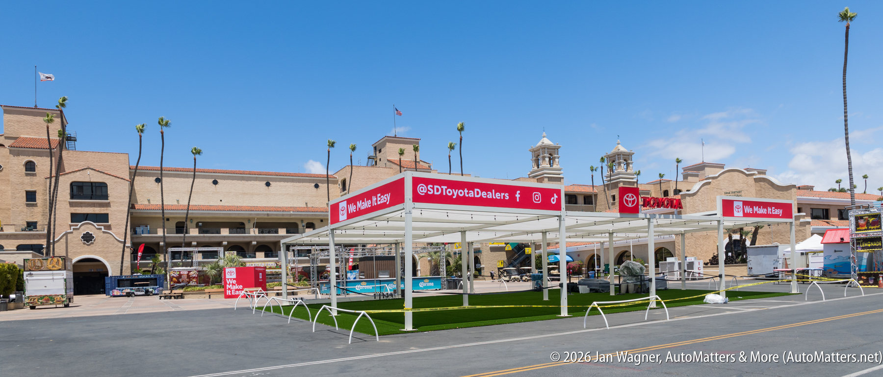 Outdoor exhibition booth for SD Toyota Dealers with red and white signage, set up in front of a large historic building under a blue sky.