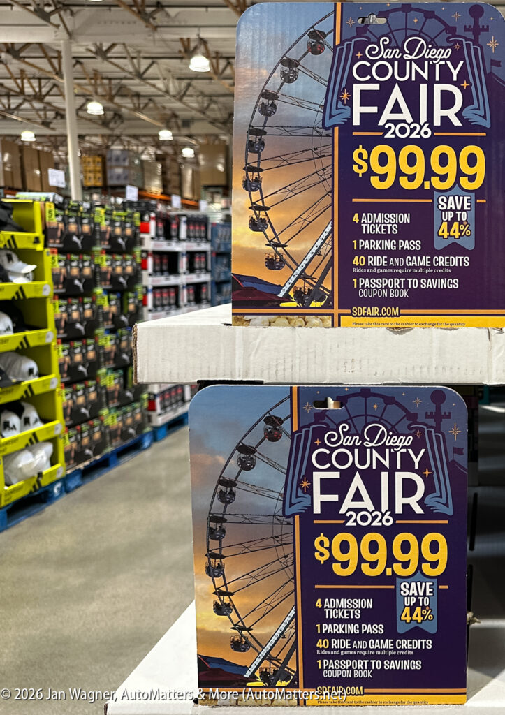 Promotional signs for the 2026 San Diego County Fair display ticket prices and offer details inside a warehouse-style store aisle.