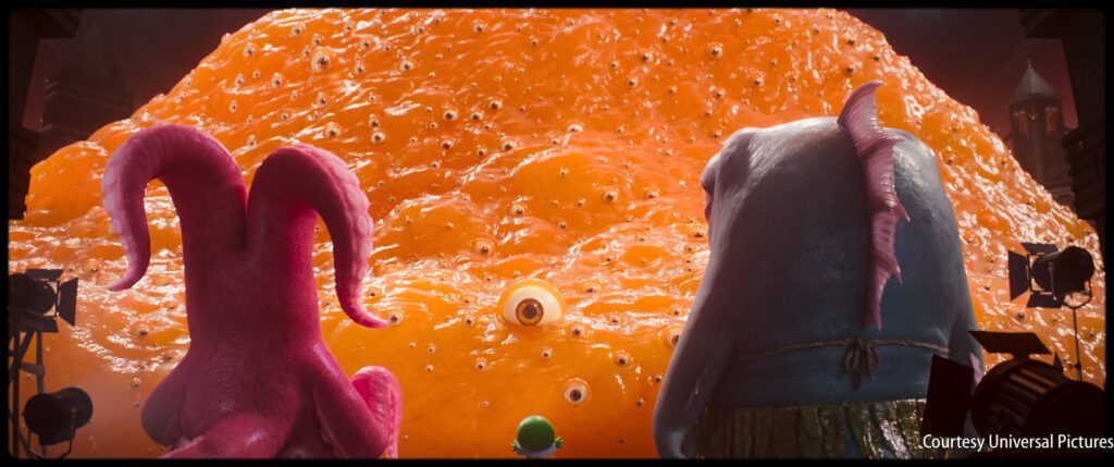 Three animated characters face a large, orange, blob-like creature with many eyes in a brightly lit scene.