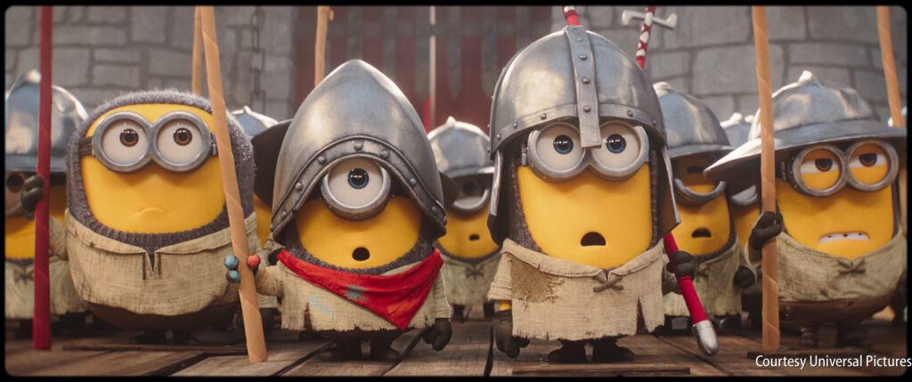 Several Minions dressed in medieval armor and tunics stand together holding spears, looking ahead with various facial expressions.