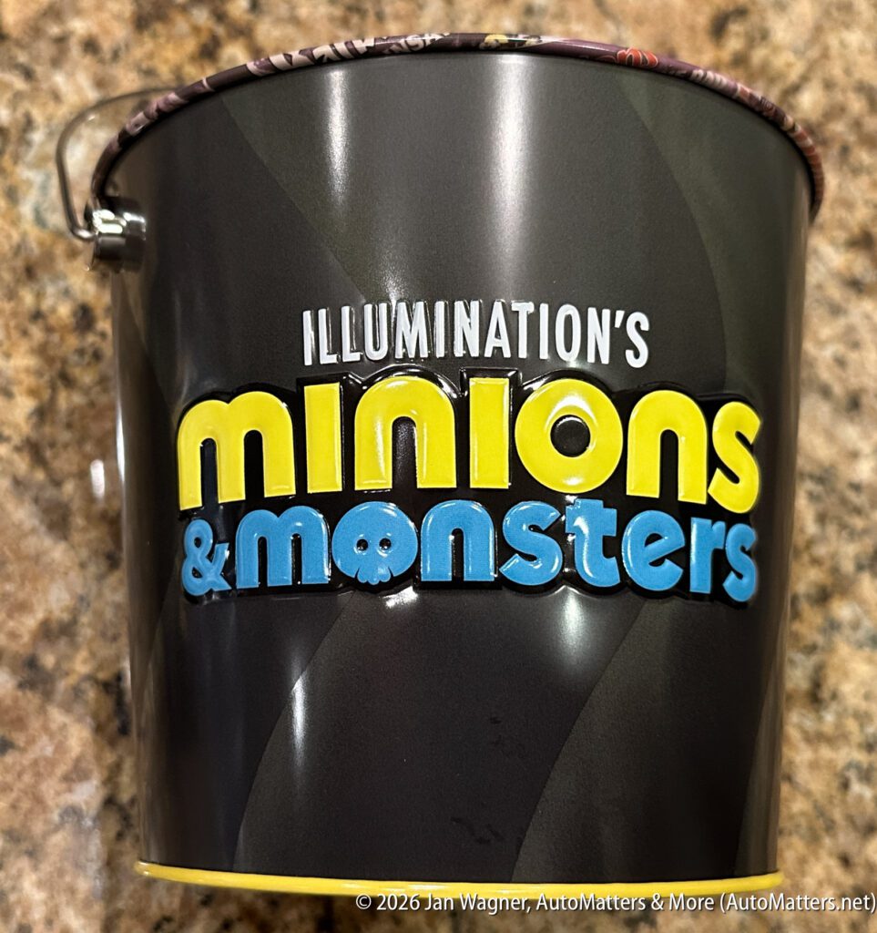 A dark-colored metal pail features the text "Illumination's Minions & Monsters" in yellow and blue lettering on the side.