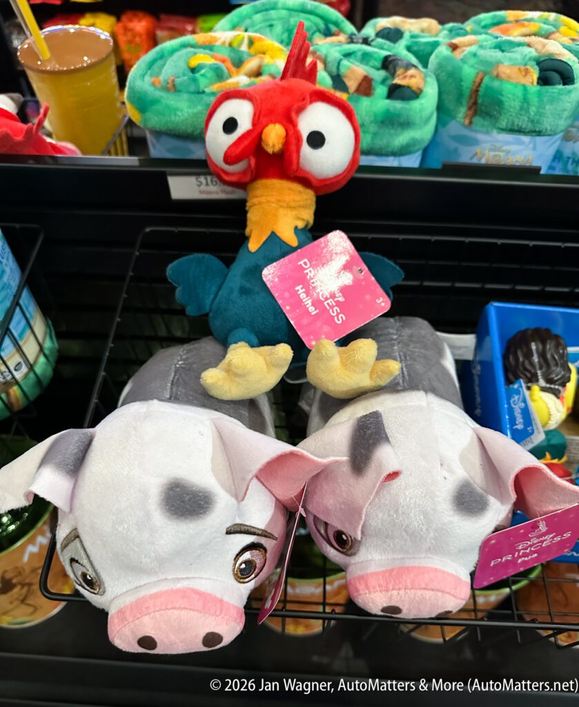 Plush toys of a rooster and two pigs from Disney’s Moana are displayed on a store shelf.