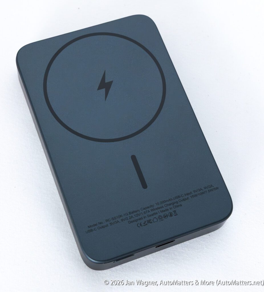 A black MagSafe-compatible portable battery pack with a circular charging symbol on top, shown on a white background.