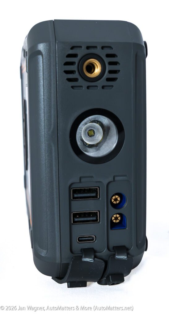Close-up of the back panel of a portable power station showing ports, including USB, DC outputs, and a vent, with surrounding protective casing.