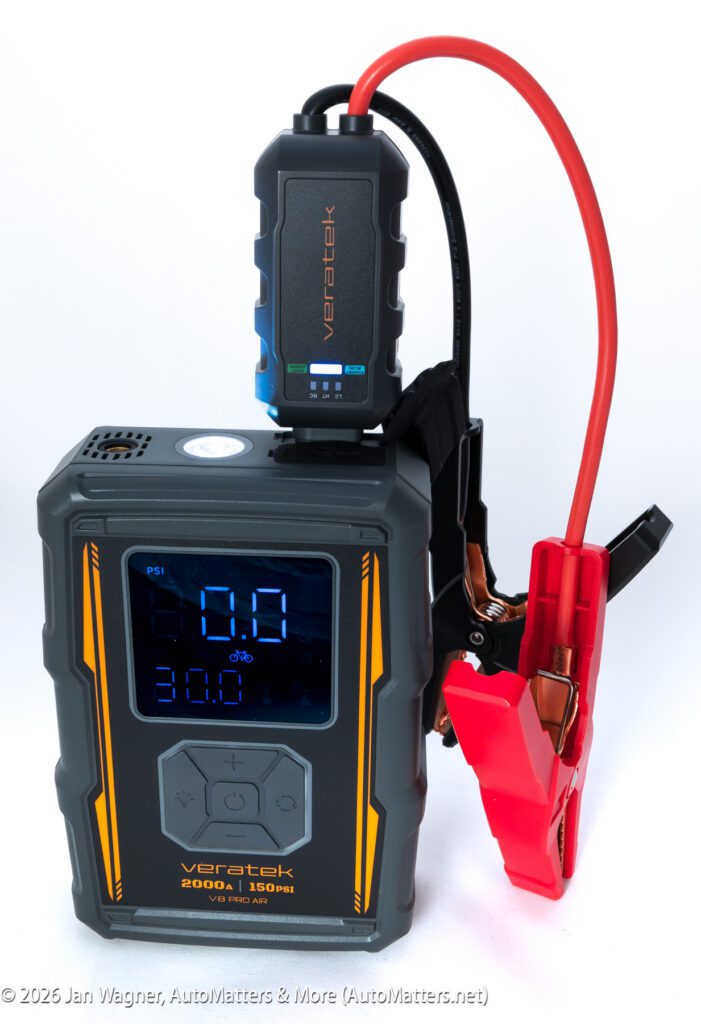 A Veratek 8200A car jump starter with display screen, attached booster cable, and digital pressure gauge, set against a white background.