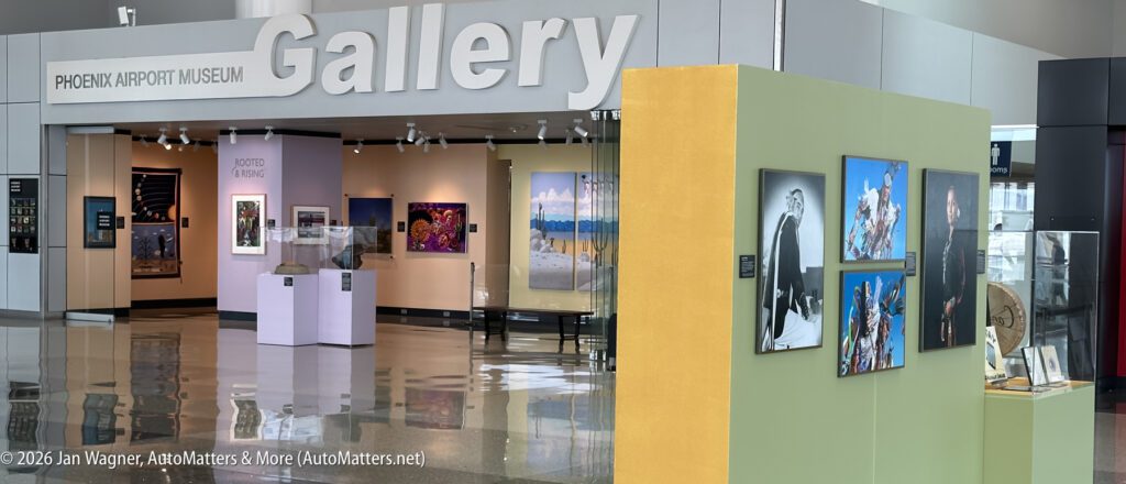 Phoenix Airport Museum Gallery entrance with colorful art displays, framed photos, paintings, and a glass display case visible in a spacious, well-lit area.