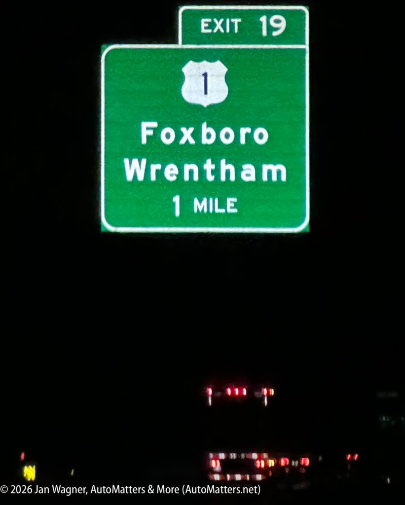 Green highway sign for Exit 19, US Route 1, indicating Foxboro and Wrentham are 1 mile ahead. The sign is illuminated at night.