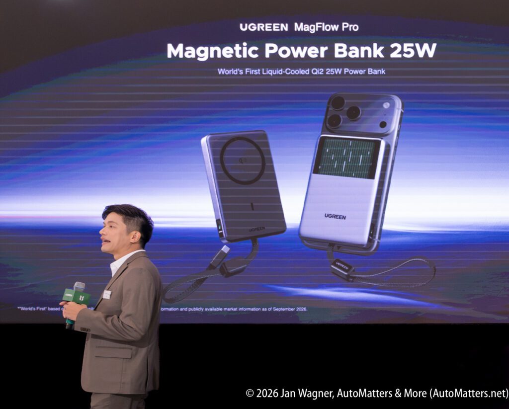 A man presents the UGREEN MagFlow Pro Magnetic Power Bank 25W on stage, with a large product image and description displayed on a screen behind him.