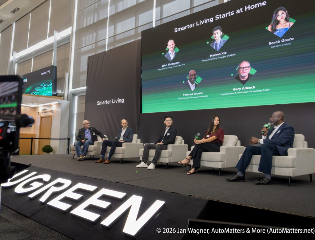 Five panelists sit on stage discussing “Smarter Living Starts at Home,” with their names and titles displayed on a large screen behind them at a UGREEN event.