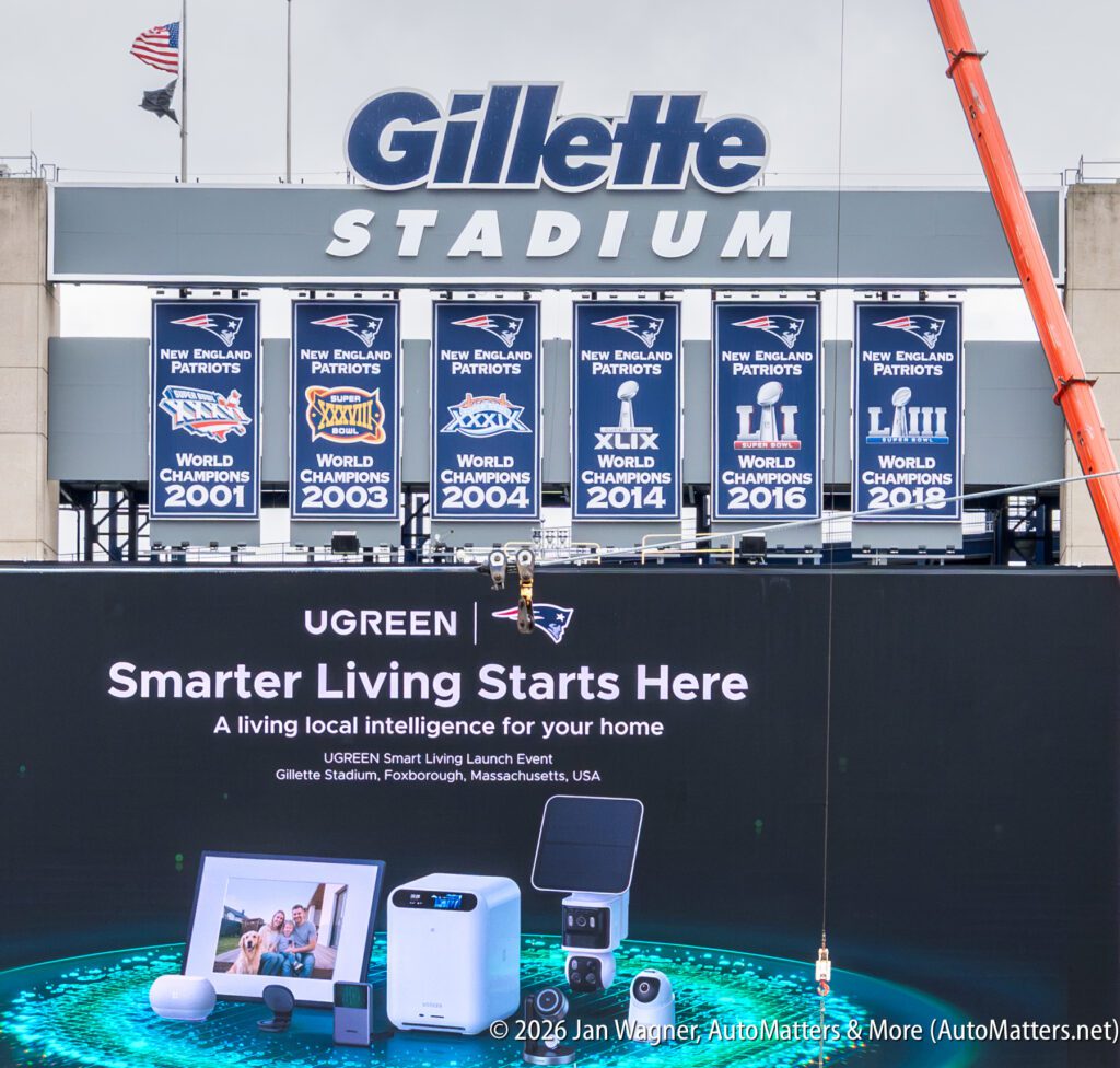Exterior of Gillette Stadium with New England Patriots’ Super Bowl banners and a UGREEN Smart Living event advertisement displayed in front.