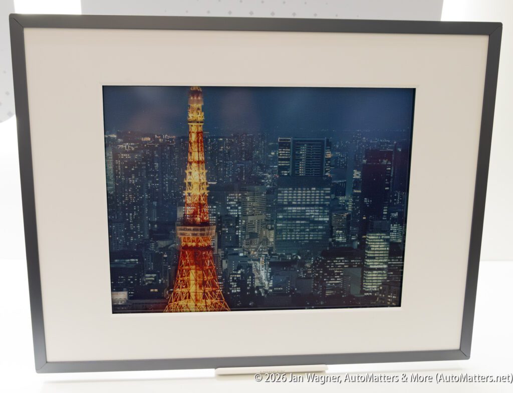 Framed photo of a cityscape at night with the illuminated Tokyo Tower in the foreground and modern buildings in the background.