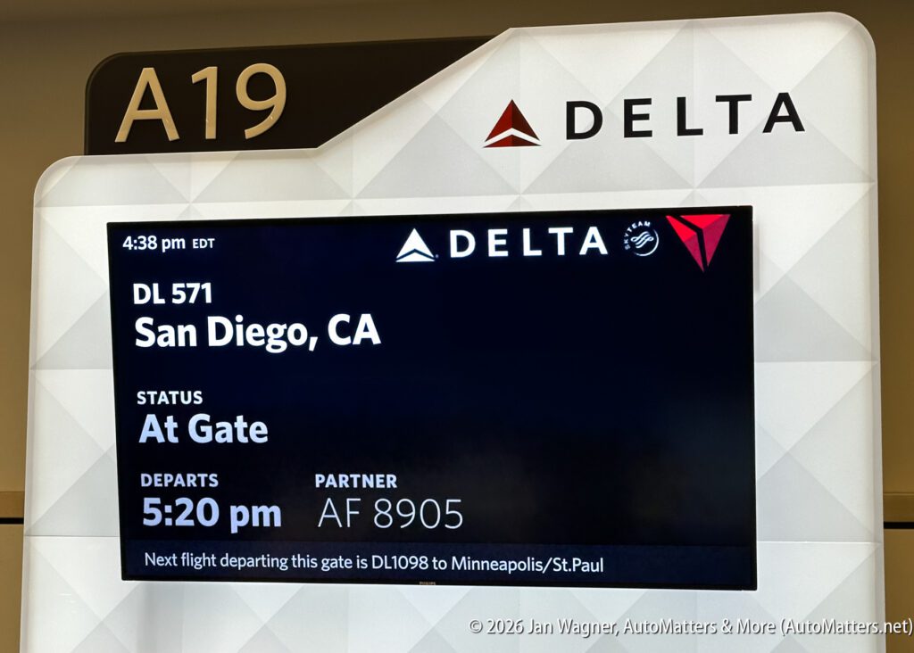 Airport gate A19 display for Delta flight DL 571 to San Diego, scheduled departure 5:20 pm, currently at gate; partner flight AF 8905 also listed.