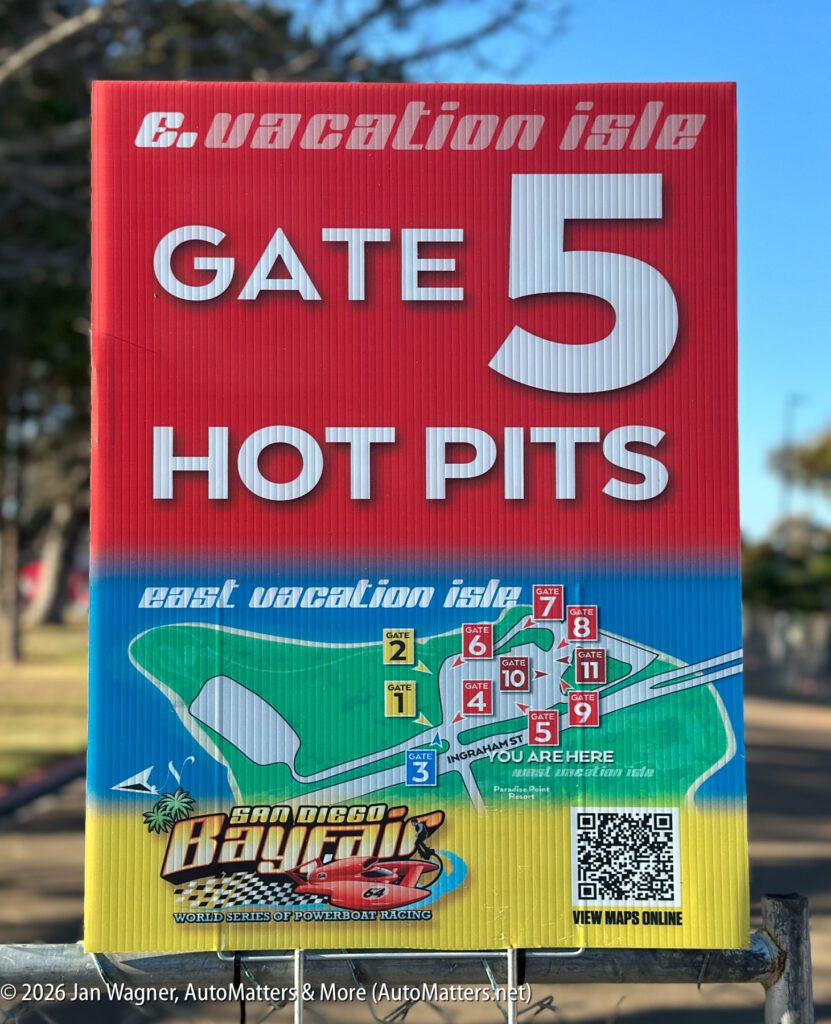 A sign for the San Diego Bayfair powerboat racing event, featuring a map of Vacation Isle gates and a QR code to view maps online.