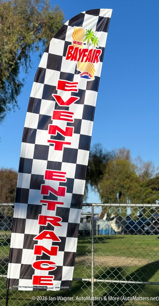 A checkered feather flag that reads “San Diego Bayfair” and “Event Entrance.”.
