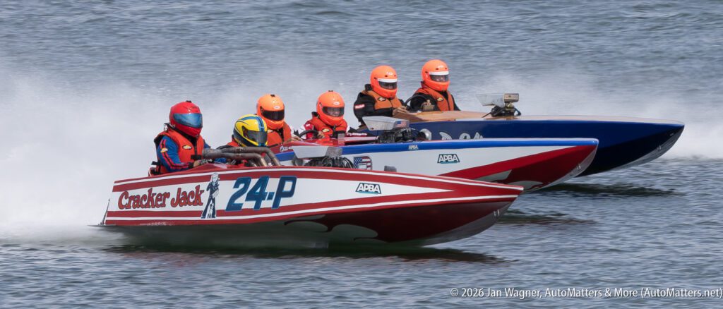 Two racing boats with multi-person crews competing on the water.