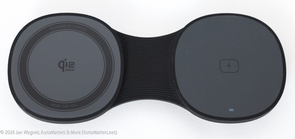 Dual wireless charging pad with textured black and gray surface, Qi2 25W logo on the left, charging symbol and indicator light on the right.