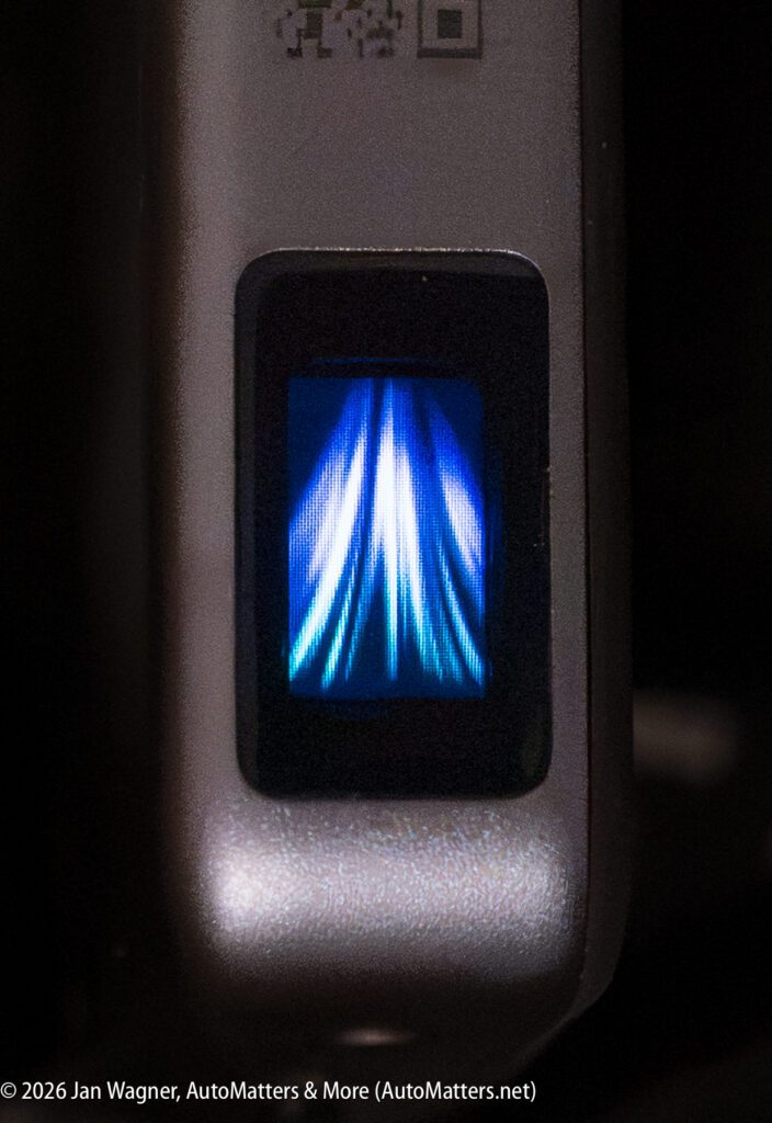 Close-up of a blue and white fingerprint scanner, illuminated and ready for fingerprint authentication on an electronic device.