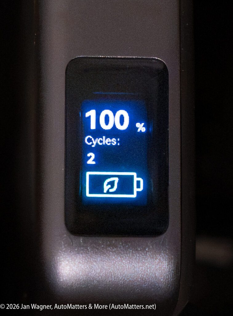A digital display shows battery at 100%, 2 cycles, and a battery icon with a leaf symbol.