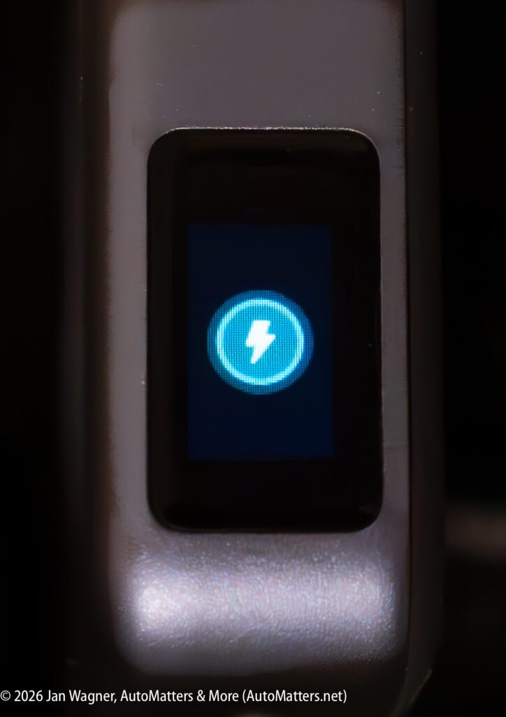 A close-up of a screen displaying a blue circular icon with a white lightning bolt, indicating charging or power.