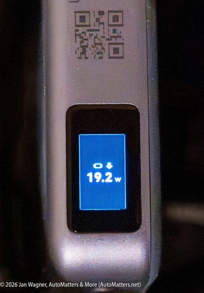 Close-up of a digital display on a device showing “19.2w” in white text, with icons above it and a QR code above the screen.