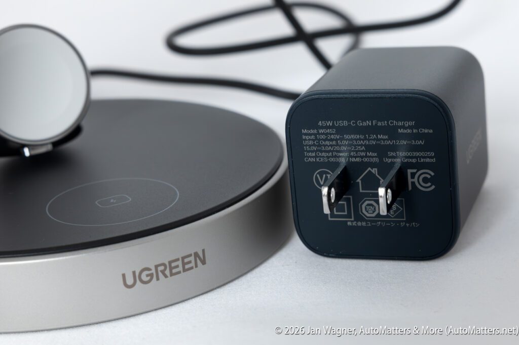 A close-up of a UGREEN wireless charging pad and a 45W USB-C GaN fast charger with prongs and printed specifications.