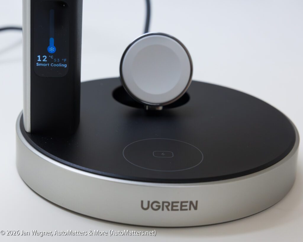 A close-up of a UGREEN charging stand with a digital smart cooling display and circular magnetic charging pad on a black and silver base.