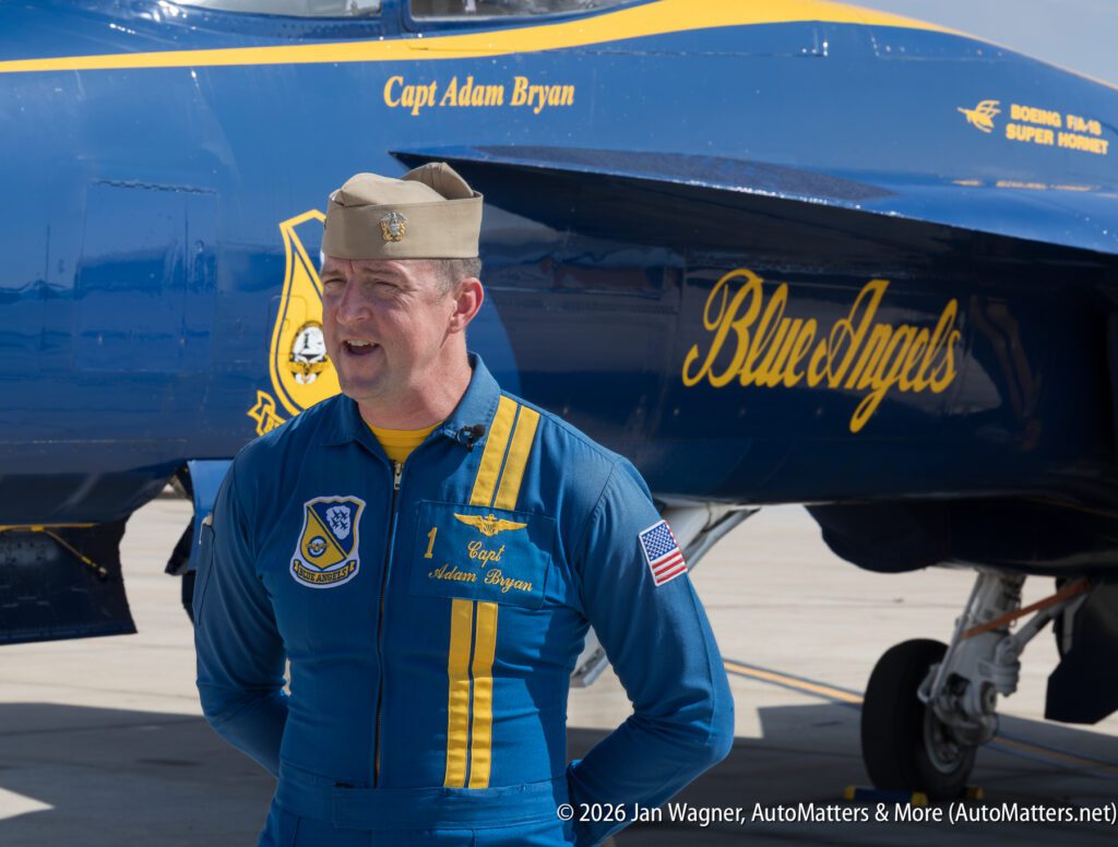 Blue Angels pilot Captain Adam Bryan standing in front of an F/A-18 Super Hornet aircraft.