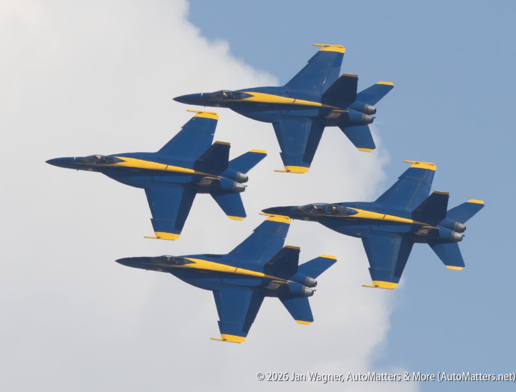 Four U.S. Navy Blue Angels F/A-18 Hornet aircraft flying in formation against a cloudy sky.