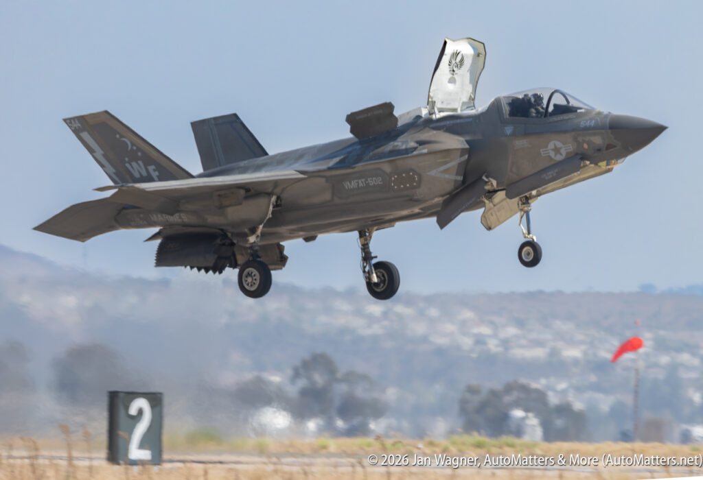 A U.S. Marine Corps F-35B Lightning II fighter jet hovering above a runway with its landing gear down.