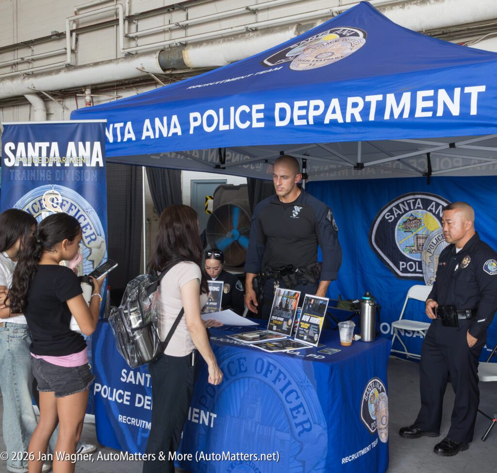Santa Ana Police Department recruitment booth with officers speaking to prospective applicants.