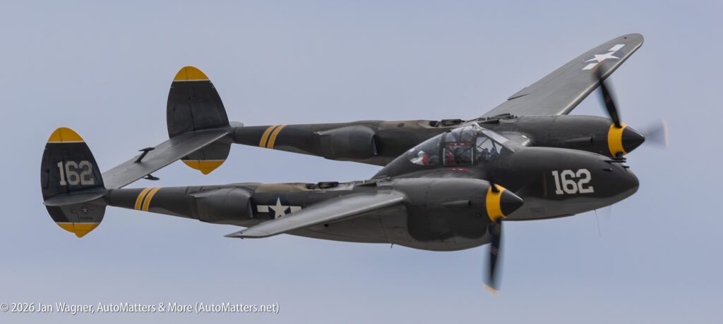 A twin-engine P-38 Lightning fighter plane in flight.