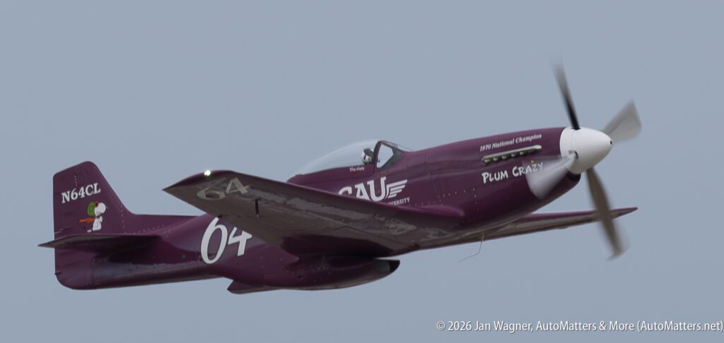 A purple P-51 Mustang race plane titled “Plum Crazy” in flight.