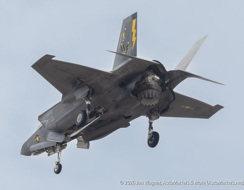 A US Marine Corps F-35B Lightning II fighter jet in flight with its landing gear extended.