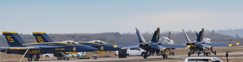 Four U.S. Navy Blue Angels F/A-18 Hornet jets parked in a line on a runway.