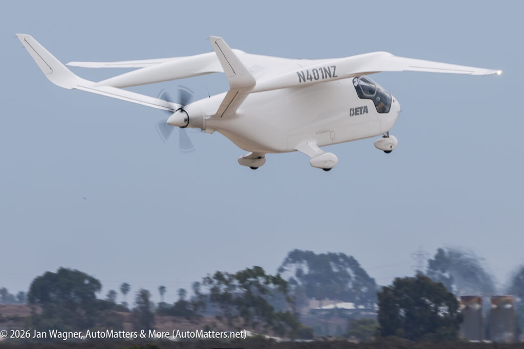 A white Beta electric aircraft marked N401NZ in flight.