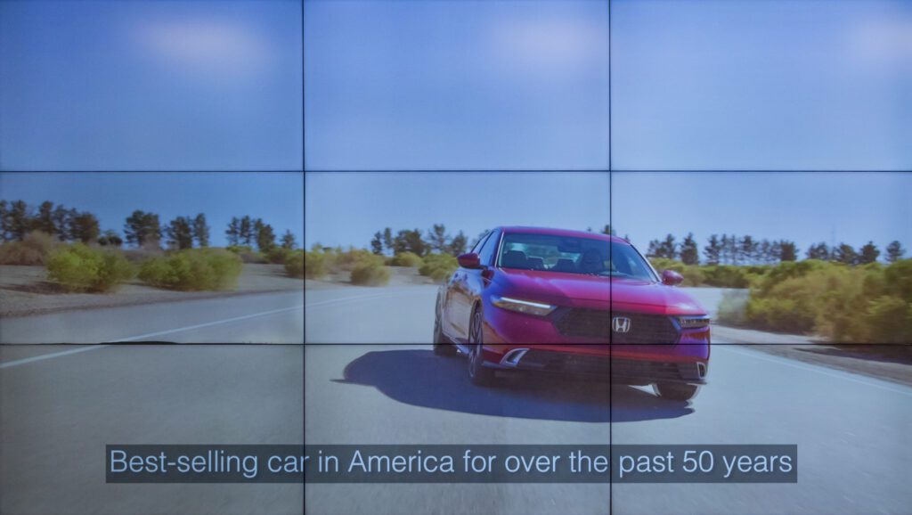 A red Honda sedan driving on a paved road with the text, “Best-selling car in America for over the past 50 years.”
