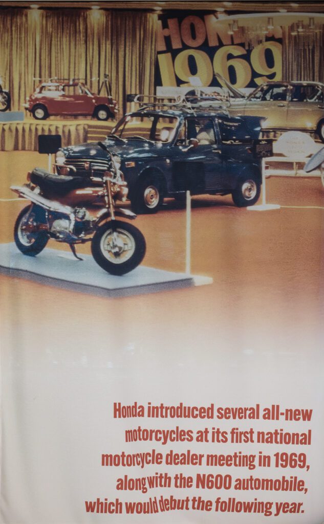 A 1969 Honda display featuring a motorcycle and an N600 car, with text describing Honda’s 1969 national dealer meeting.