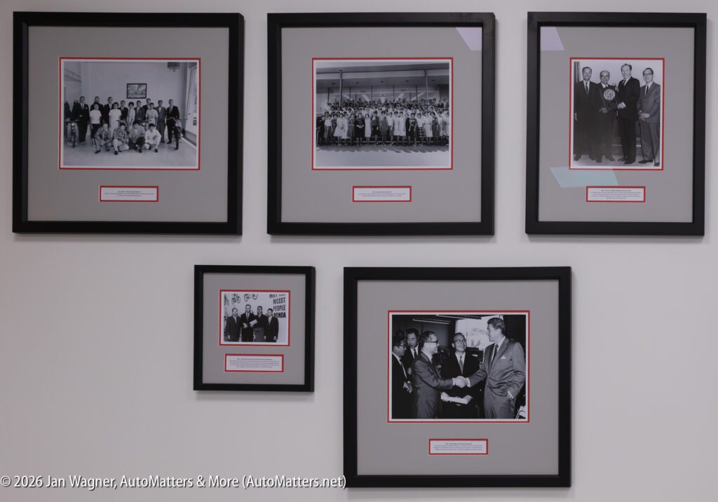 Five framed black-and-white historical photographs of Honda executives and groups displayed on a white wall.