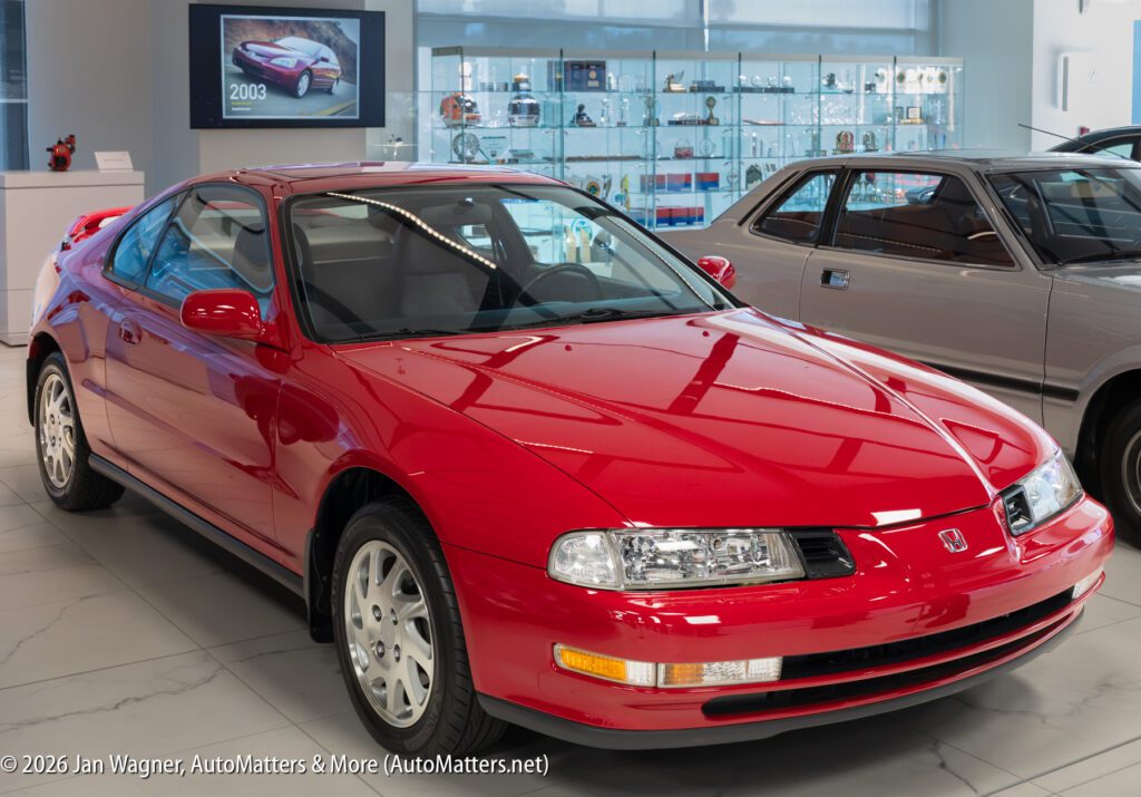 A bright red Honda Prelude parked in a showroom.